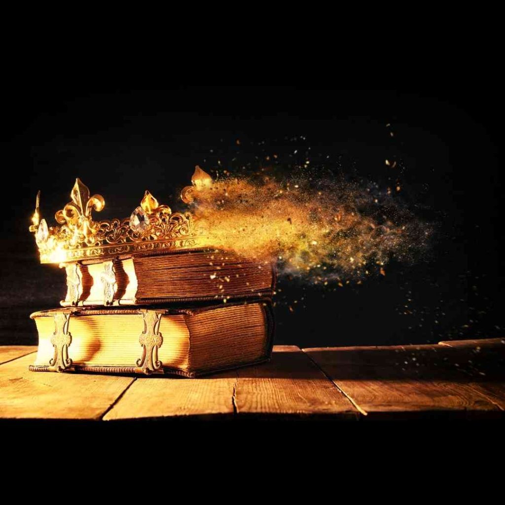 A picture to serve as inspirtation for a #sixwordstory--A crown flames out with golden dust. It sits atop two ancient looking books on a wooden table.