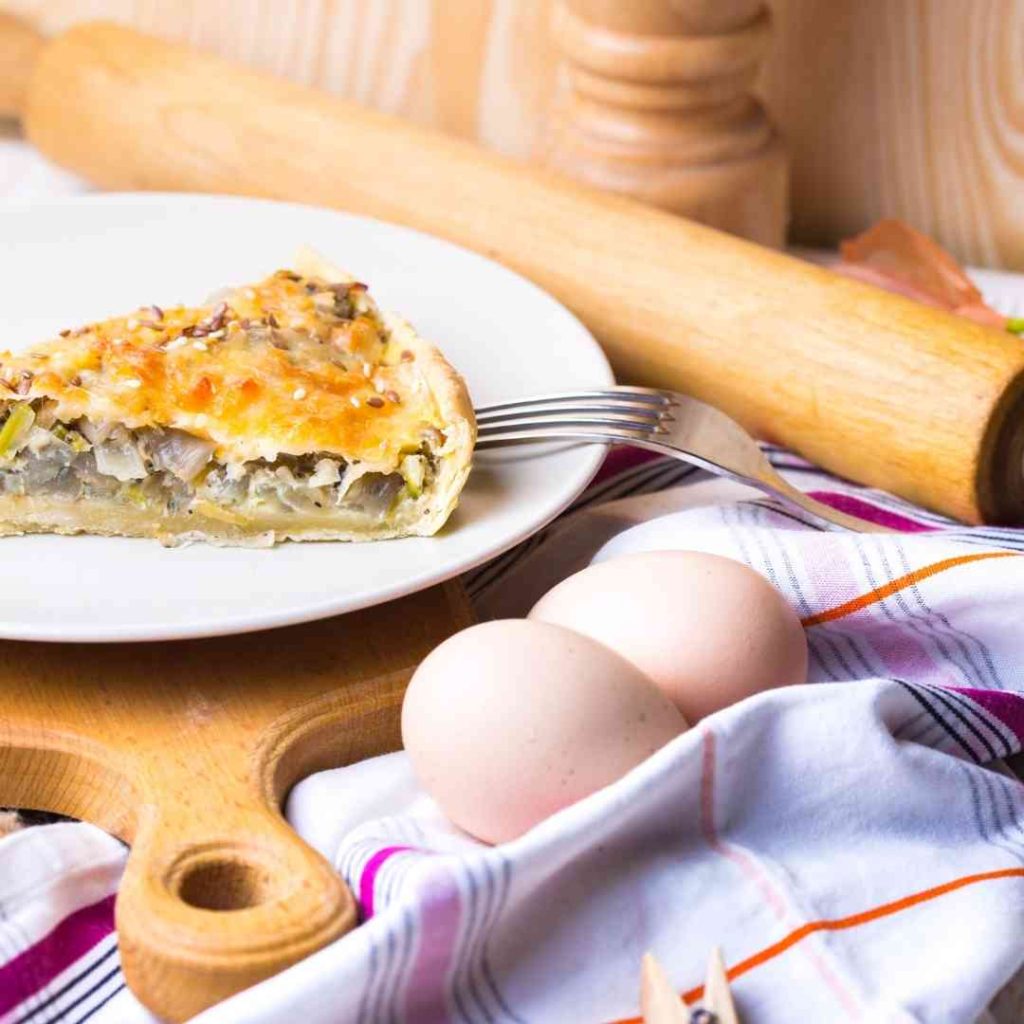 Hamburger Onion Pie on a plate, with various kitchen implements suggesting it is homemade.